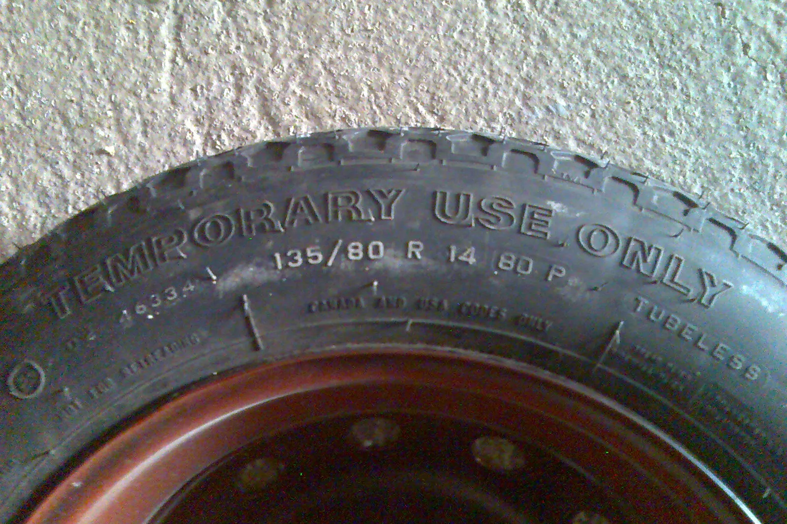 Боковина запасного колеса з маркуванням 135/80 R 14 80 P і написом TEMPORARY USE ONLY